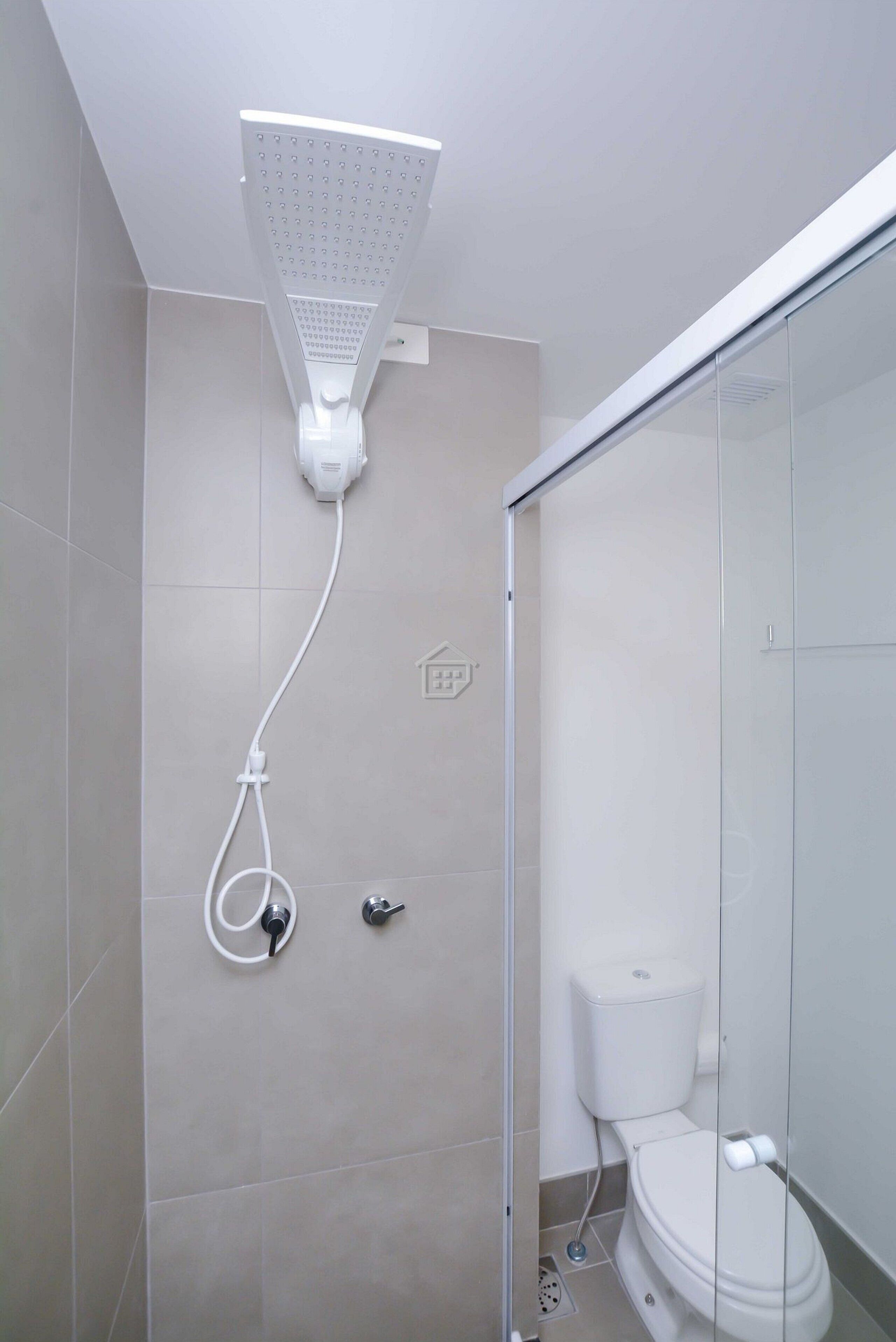 Un baño moderno con ducha, inodoro y cabina de ducha con paredes de vidrio.
