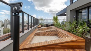 A rooftop terrace with a wooden deck, a telescope, and a view of the cityscape. - Panoramic View in Porto Alegre MJ08H (Porto Alegre)
