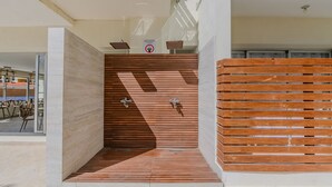 A modern bathroom with a wooden slatted wall, a shower area, and a sign indicating no towel drying. - Apartamento Delicado Próximo a la Playa (Boca Chica)