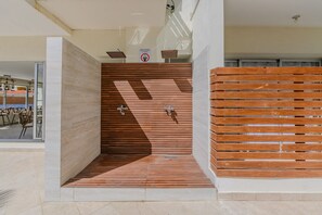 A modern bathroom with a wooden slatted wall, a shower area, and a sign indicating no towel drying. - Apartamento Delicado Próximo a la Playa (Boca Chica)