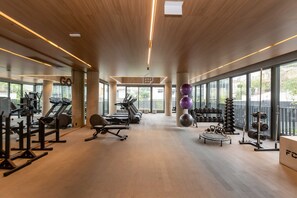 A spacious gym with treadmills, weight machines, and free weights. - Studio Elegante e Conectado em Porto Alegre (Porto Alegre)
