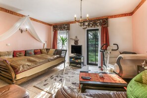 A room with a bed, a television, a chair, and a window with curtains. - Apartment 'Bali - 33 M²' with Wi-Fi (Hoppegarten)