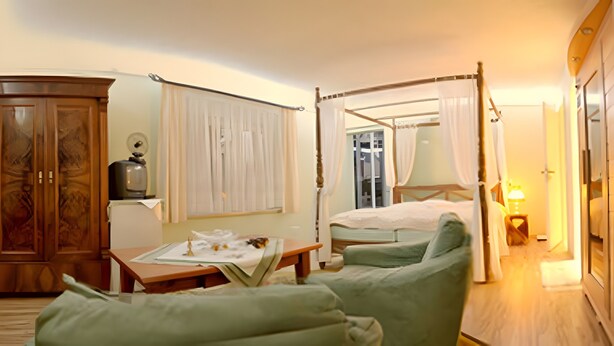 A hotel room with a bed, a wooden wardrobe, a small table with a lamp, and a window with curtains. - Apartment "La Vida" for 3 Guests, 60 m² with Shared Garden, Wi-Fi and Air Conditioning (Hoppegarten)