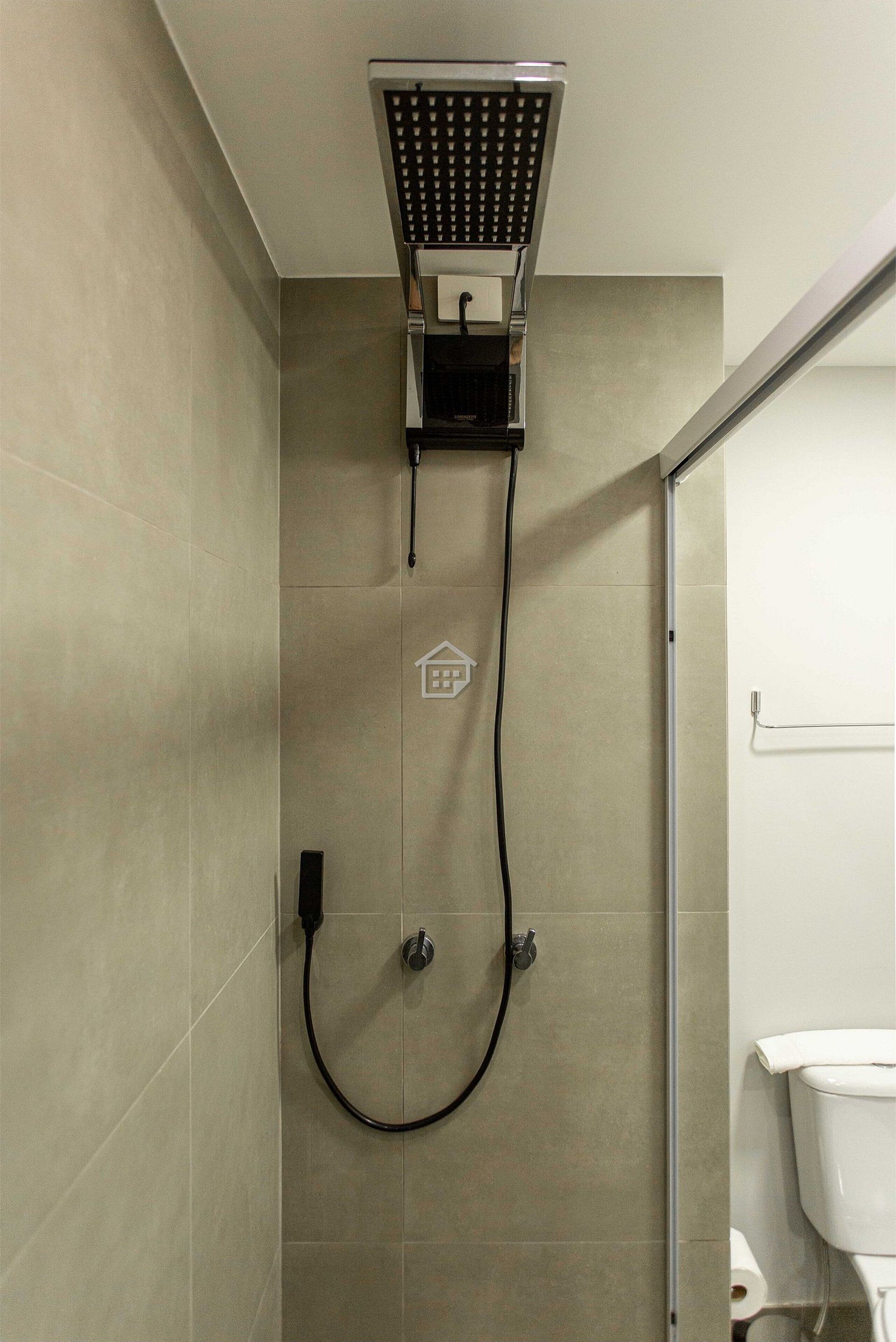 Ducha con panel de control, manguera y un inodoro fijado a la pared.