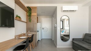 Eine moderne Küche mit Holzarbeitsplatte, schwarzen Stühlen und einem eingebauten Fernseher.