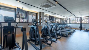 A gym with multiple treadmills, exercise bikes, and a large window with a city view. - O Seu refúgio de estilo no coração do Moinhos (Porto Alegre)