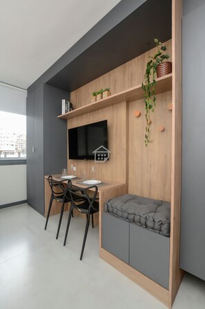 Una cucina moderna con zona pranzo, televisione a schermo piatto e finestra vista città.