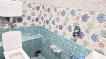 Klassieke vierpersoonskamer | Badkamer | Een douche, handdoeken, zeep, shampoo