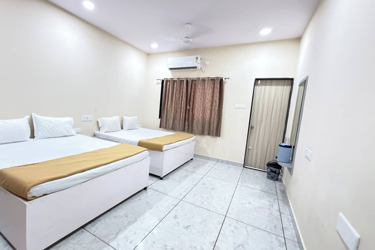 A hotel room with two beds, a ceiling fan, an air conditioning unit, a wooden door, and a tiled floor.