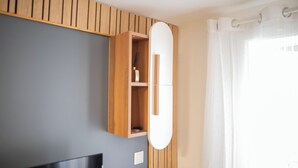 Une salle de bain avec un meuble-lavabo en bois, un miroir et un rideau de douche.