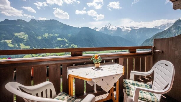 A balcony with a table and chairs, overlooking a mountainous landscape. - Gasthof Pension Berghof (Hippach-Schwendberg)