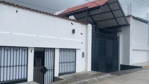 A building with a white facade, a red roof, and a gated entrance. - Condor Palace (Huayllay)
