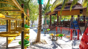 A playground with various play structures including swings, slides, and climbing areas. - Hoàng Long Tropical - Farmstay (Ham Thanh)