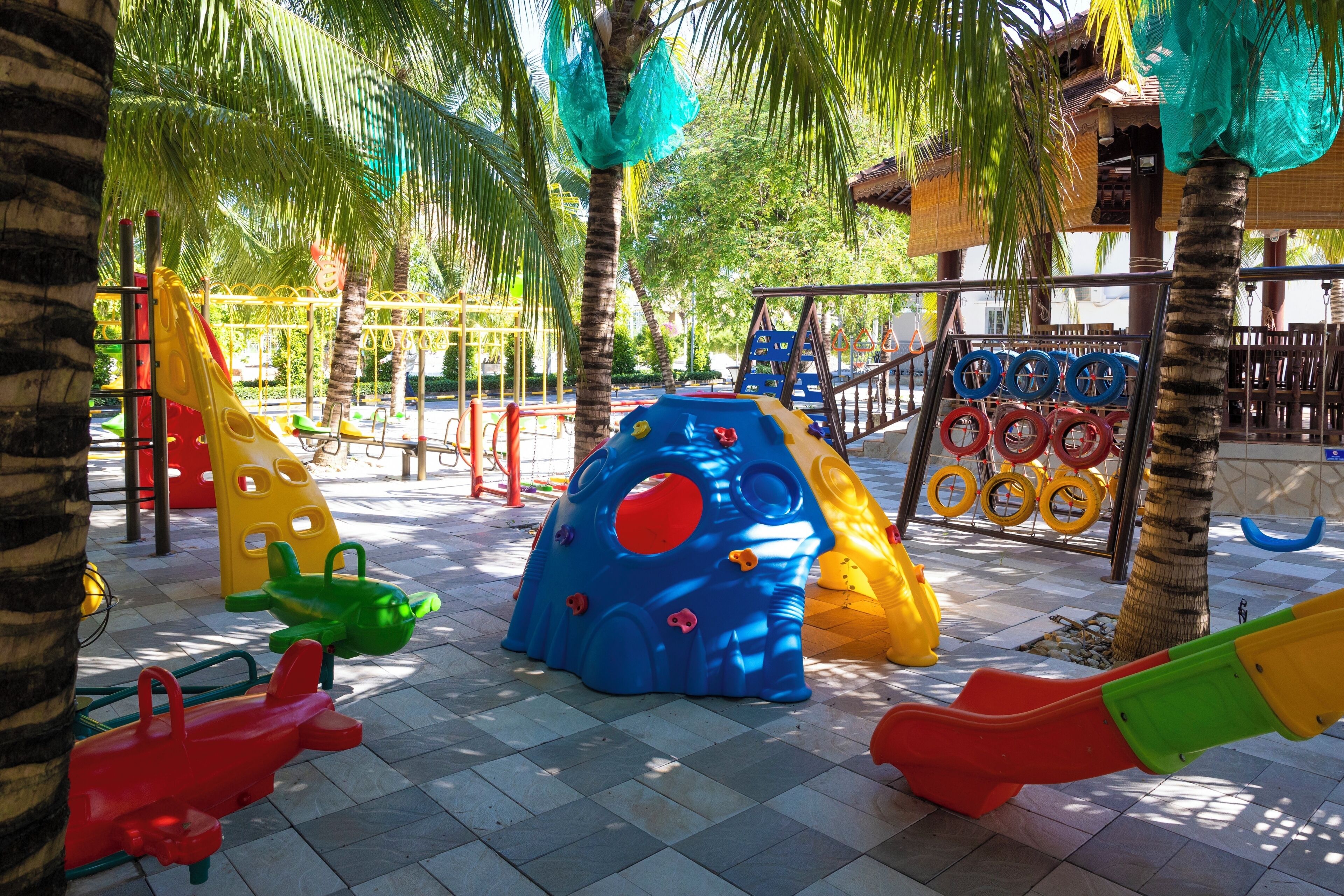 A playground with various play structures including slides, climbing areas, and a ball pit.