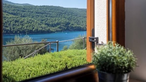A view of a lake with a forested hillside, a railing, and a potted plant. - 210 Sea Side 2bedrooms Holiday Apartment SeaView (Duga Luka)