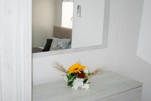 A bathroom with a mirror, a sink, and a small flower arrangement on the counter. - Apartment 'Adriatic Breeze' with Private Terrace and Air Conditioning (Melendugno)