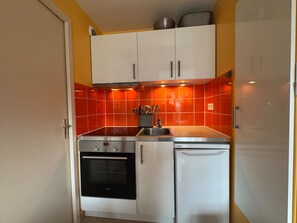 A compact kitchen with a Siemens oven, a built-in sink, and a refrigerator. - Renovated and Bright Apartment - Direct Sea Access (Cabourg)