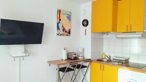 A compact kitchen with a TV, a coffee maker, a toaster, and a washing machine. - AC Studio with Parking in Sanary-sur-Mer (Sanary-sur-Mer)