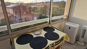 A balcony with a table, chairs, and a view of buildings. - AC Studio with Parking in Sanary-sur-Mer (Sanary-sur-Mer)