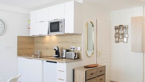 Una cocina compacta equipada con microondas, tostadora y lavabo.