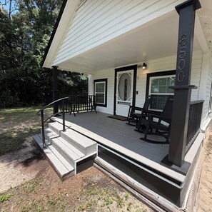 A house with a porch, steps, and a mailbox. - The 1918 Magnolia Cottage (Milton)