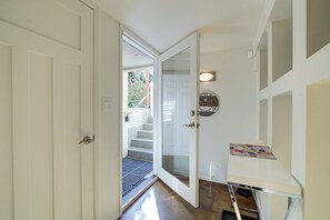 A hallway with a white door, a staircase, and a small table with a decorative item. - Lovely 2-bedroom apartment in Seattle in vibrant Wallingford Neighborhood (Seattle)
