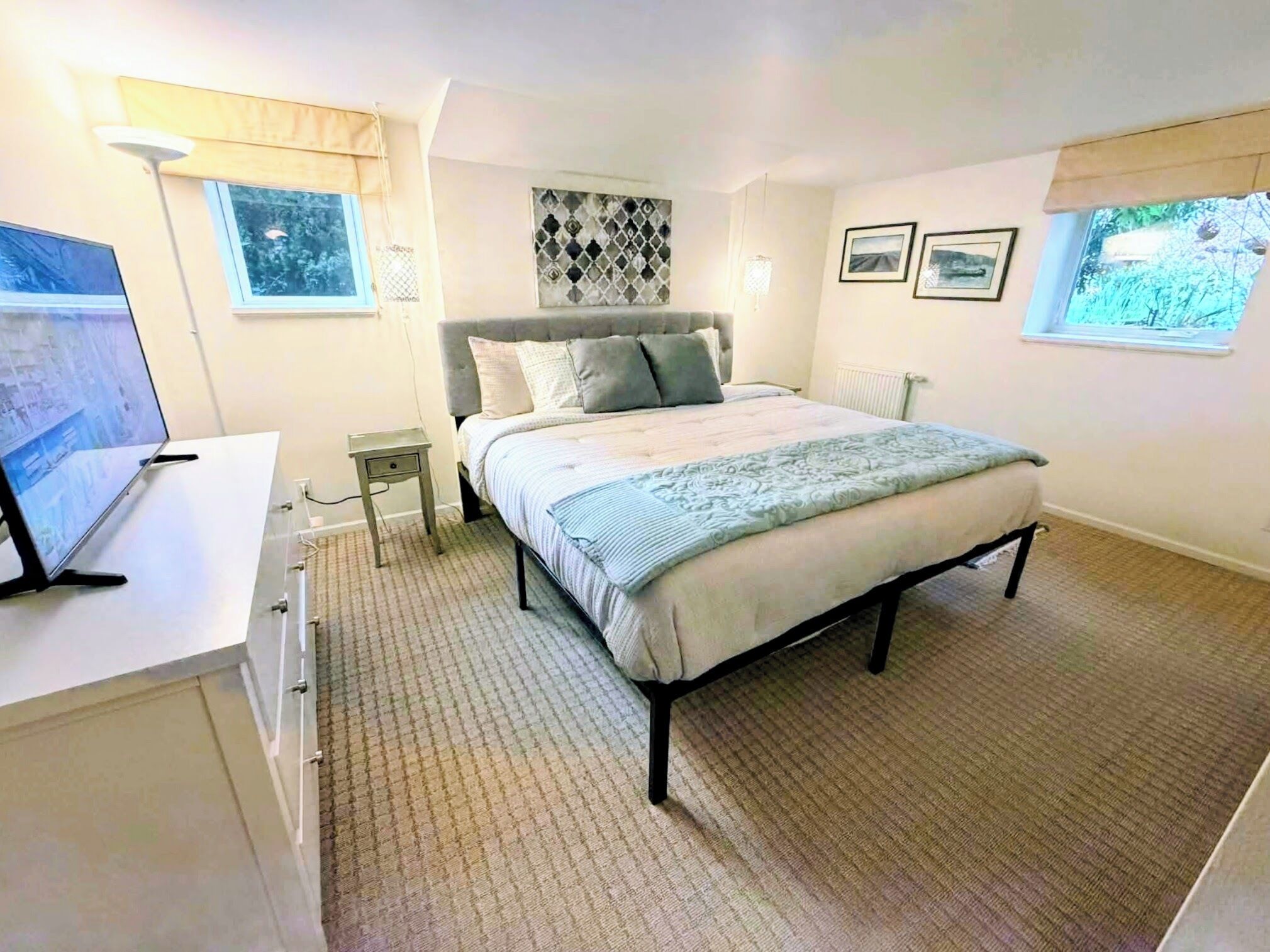 Une chambre à coucher avec un lit, un bureau, une lampe et une fenêtre.