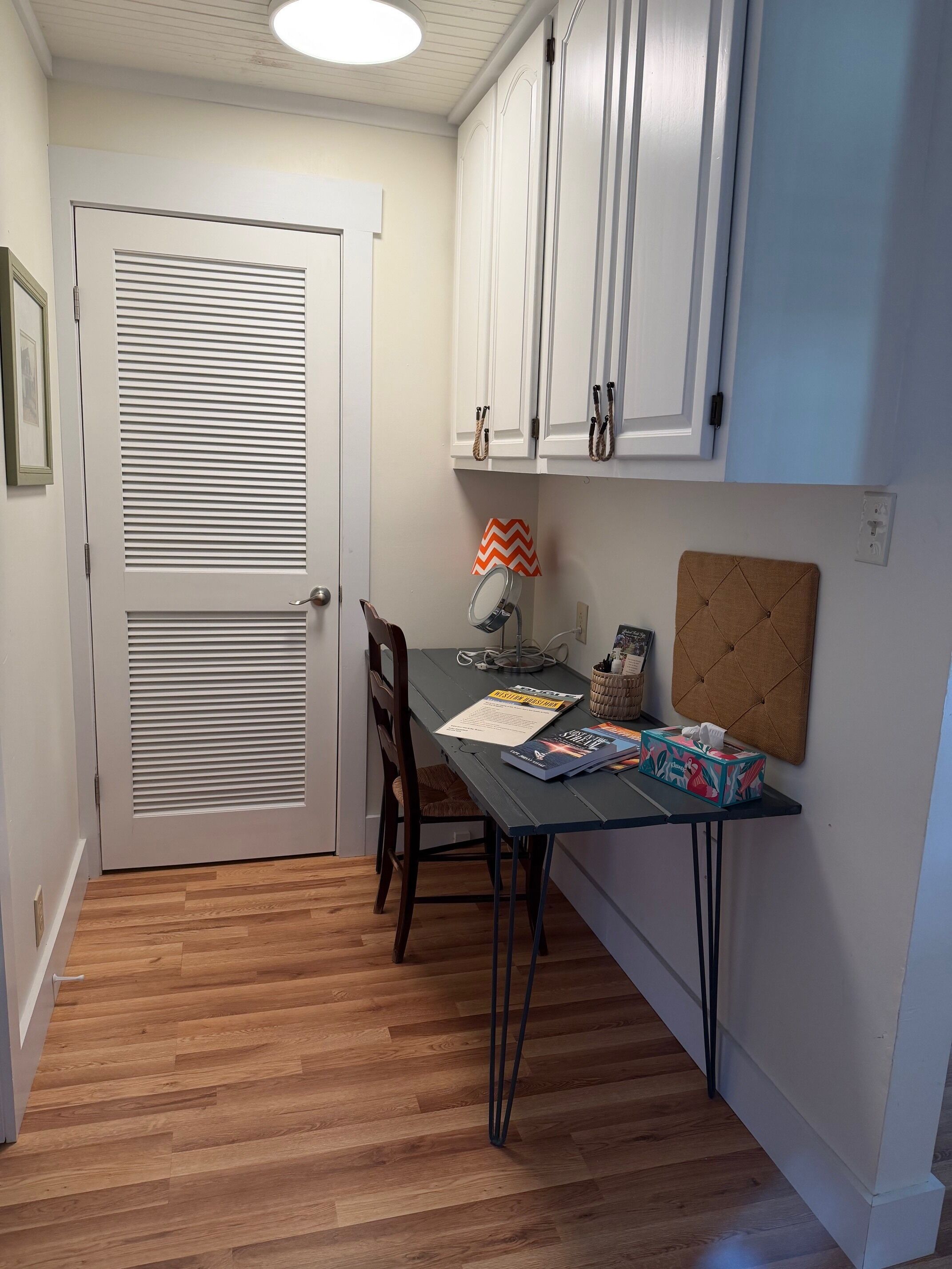 Une cuisine comprenant une table à manger, des chaises, un buffet et une porte à panneaux ajourés.