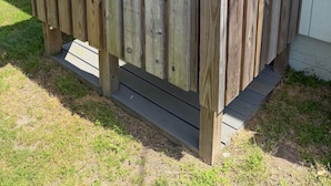 Une structure en bois dotée d’une porte, d’un escalier et de décorations sphériques colorées.