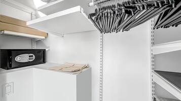 A kitchen with a microwave, a knife rack, and a shelf with a bag.