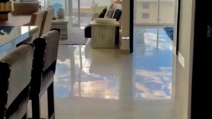 A modern interior with a dining area, a sofa, and a view of the city through large windows. - Contemporary Condo with Ocean Views (Mazatlan)