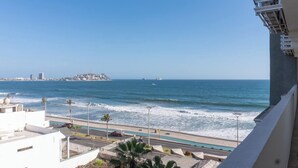 A coastal view with a road, a swimming pool, and a distant island. - Contemporary Condo with Ocean Views (Mazatlan)
