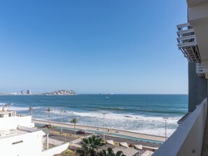 Blick auf die Küste mit einer Straße, einem Schwimmbad und einer entfernten Insel.