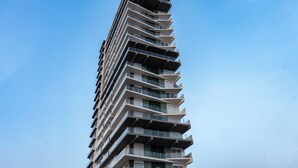 A high-rise building with multiple balconies and a clear sky. - Contemporary Condo with Ocean Views (Mazatlan)