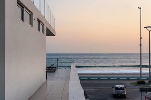 A coastal view with a building, a road, and a car. - Luxurious 2 bedroom condo with partial ocean view (Mazatlan)