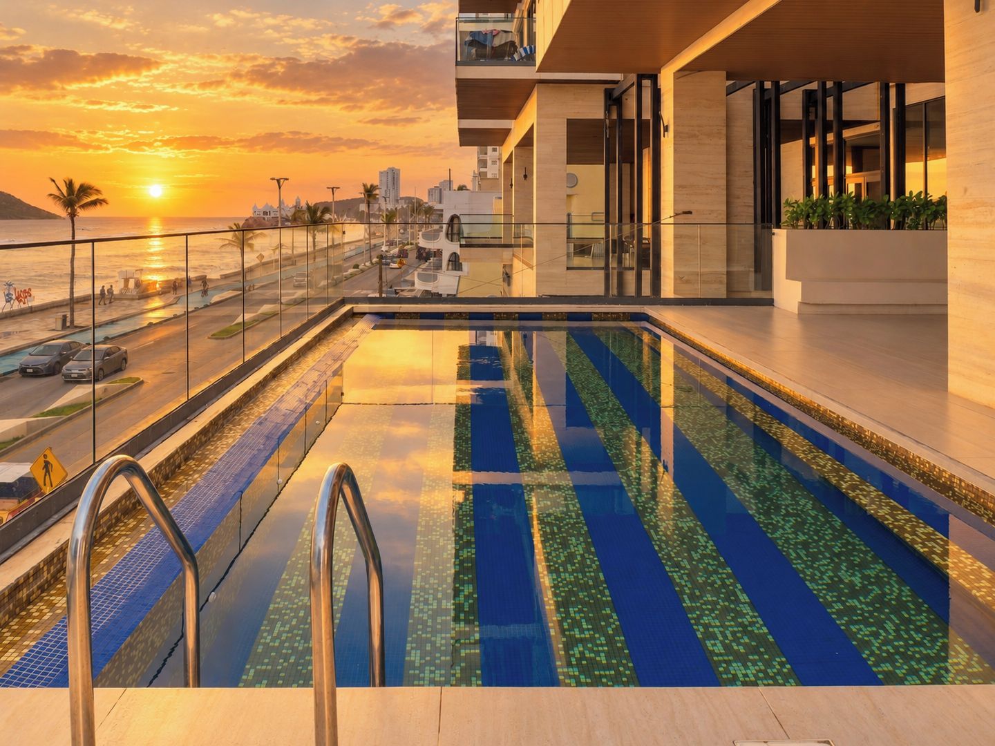 A swimming pool with a view of the sunset and cityscape.