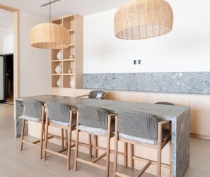 A modern kitchen with a marble countertop, wicker chairs, and pendant lights. - Luxury apt on the Malecón with lagoon views (Mazatlan)
