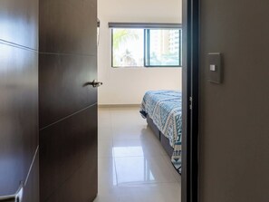 A bedroom with a bed, a window, and a door. - Family apartment with roof and great location (Mazatlan)