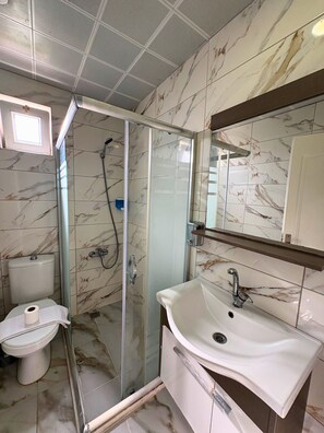 Quarto triplo luxo, sacada, vista parcial para o mar | Banheiro