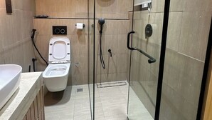Un baño moderno con ducha envuelta en vidrio, inodoro y lavamanos.