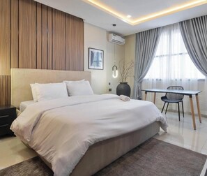 A modern hotel room with a large bed, a small table, and a chair. - 59 HOTEL (Ishara)
