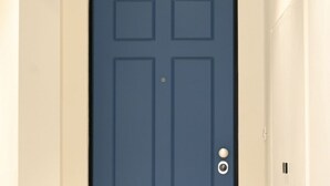 A dark blue door with a keyhole and a round doorknob.