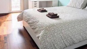 Un dormitorio con una cama, una ventana, un escritorio y una silla.