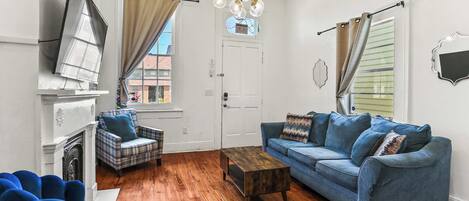 A living room with a fireplace, a sofa, a coffee table, and a blue armchair.