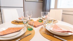 Ein Esszimmertisch ist gedeckt mit Tellern, Gläsern, Besteck und einer Speisekarte.