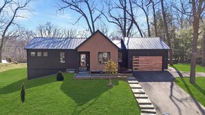 A modern two-story house with a sloped roof, a front garage, and a well-maintained lawn.