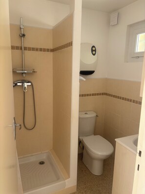 Ein Badezimmer mit Dusche, Toilette und Waschbecken.