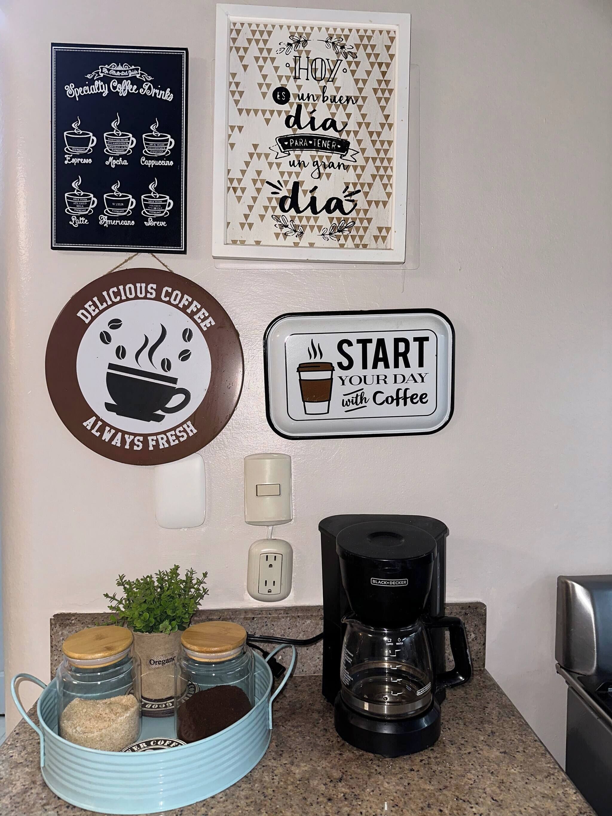 A kitchen counter with a coffee maker, jars of coffee beans, and a sign that says 'Start your day with coffee.'
