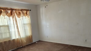 A room with a carpeted floor, a ceiling fan, and sheer curtains. - Nice 3-bedroom house with AC in peaceful Lubbock neighborhood (Lubbock)