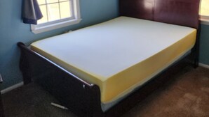 A single bed with a wooden headboard in a room with blue walls and a window with curtains. - Nice 3-bedroom house with AC in peaceful Lubbock neighborhood (Lubbock)